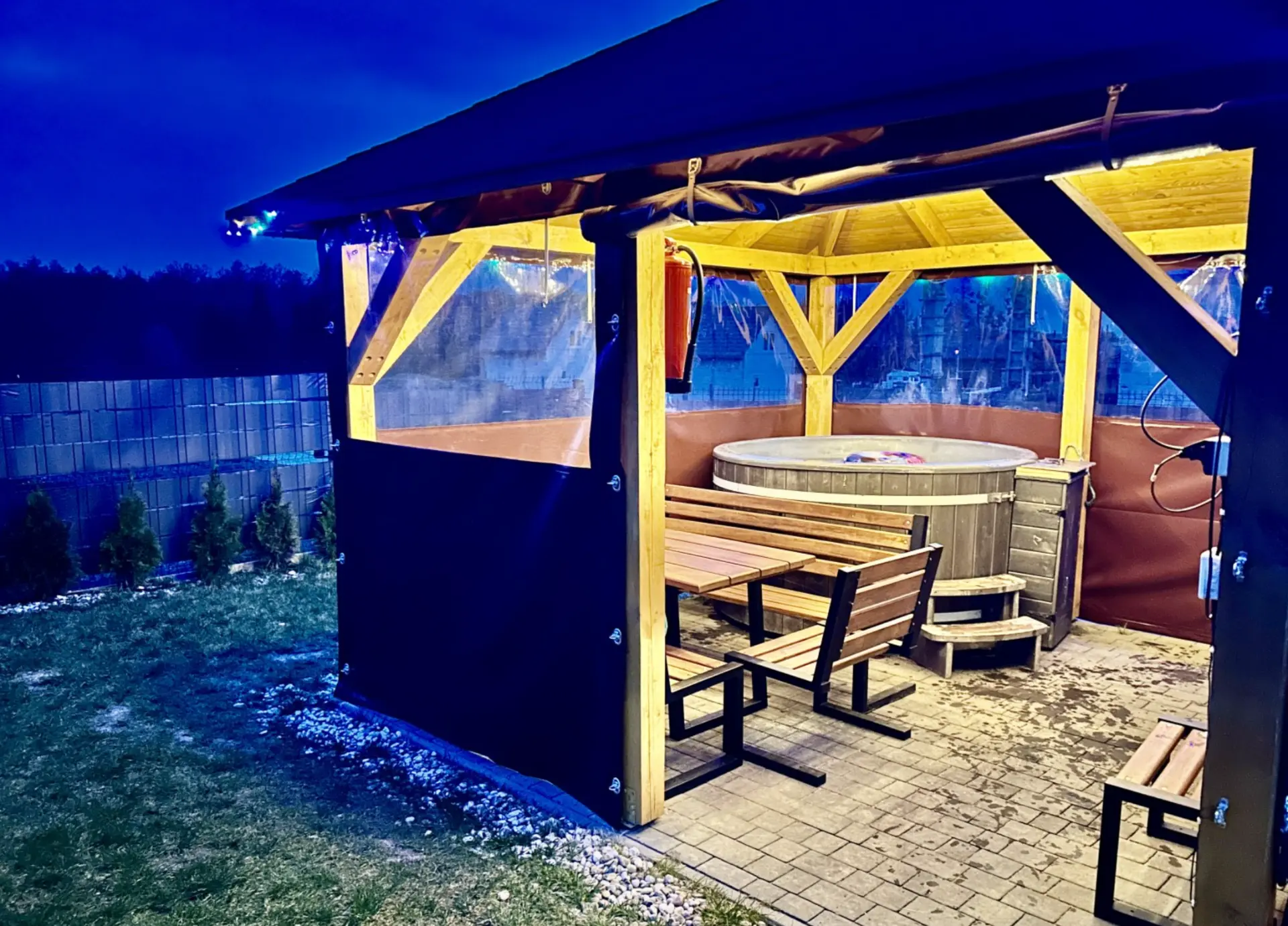Balia z hydromasażem w zadaszonej altanie nocą