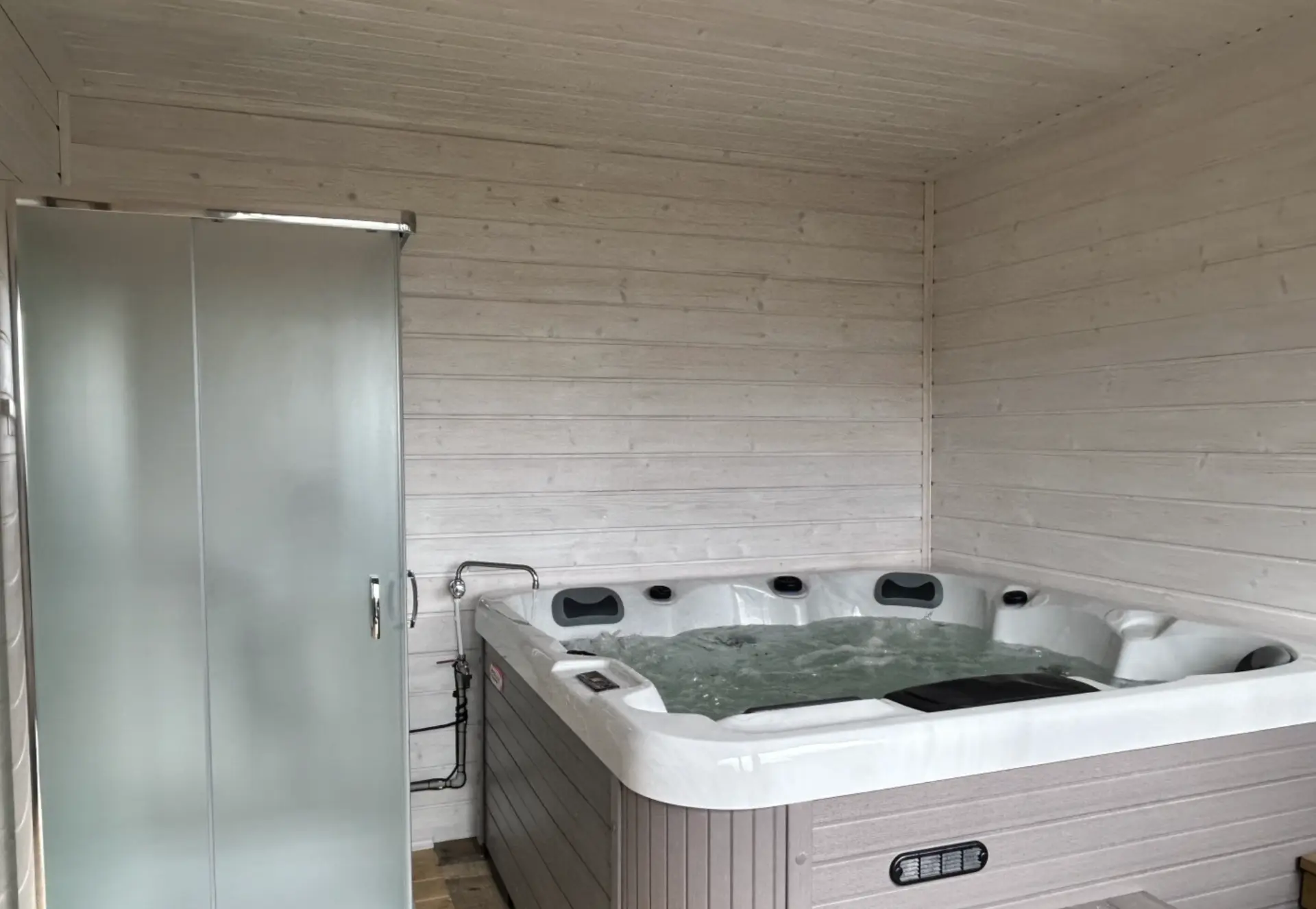 Jacuzzi z hydromasażem w jasnym drewnianym pomieszczeniu